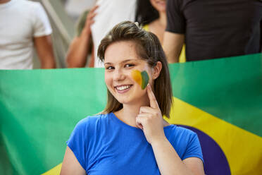 Lächelnde Frau zeigt Brasilien Flagge auf dem Gesicht gemalt - ZEDF04726