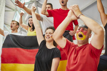 Young fans with German Flag cheering together at sports event in stadium - ZEDF04737