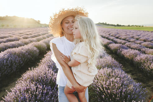 Smiling woman with daughter standing in lavender field - SIF00267