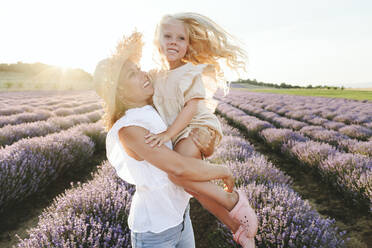 Happy woman with daughter enjoying in lavender field - SIF00268