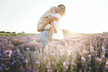 Happy mother giving piggyback ride to daughter - SIF00273