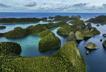 Luftaufnahme von verstreuten Inseln mit blauem Meerwasser auf der Insel Wajag, Raja Ampat, West Papua, Indonesien. - AAEF14972