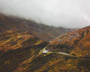 Aerial view of an abstract sculpture along the road on the mountain with fog, Norway. - AAEF14997