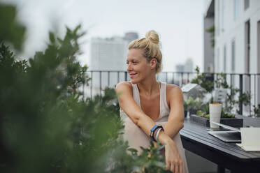 Kaukasische Frau sitzt auf Balkon - TETF01649