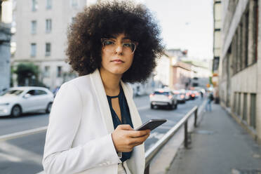 Junge afroamerikanische Geschäftsfrau mit Mobiltelefon - MEUF06859