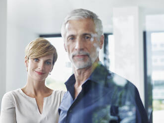 Smiling businesswoman with businessman in office - RORF02916