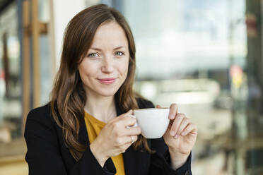 Geschäftsfrau mit Kaffeetasse im Cafe - DIGF18224