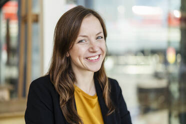 Happy businesswoman with brown hair at cafe - DIGF18225