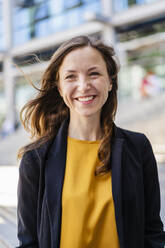 Happy businesswoman with brown hair wearing blazer - DIGF18252