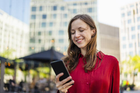 Lächelnde Frau mit Mobiltelefon - DIGF18277