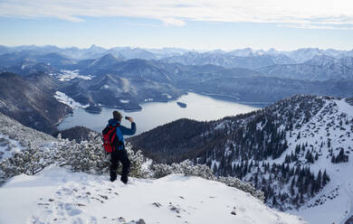 Wanderer fotografiert Walchensee und Bayerische Voralpen vom Herzogstand aus, Bayern, Deutschland - PSBHF00021