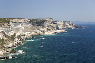 Blick entlang der zerklüfteten Kalksteinklippen auf Capo Pertusato und die ferne Küste Sardiniens, Bonifacio, Corse-du-Sud, Korsika, Frankreich, Mittelmeer, Europa - RHPLF22416