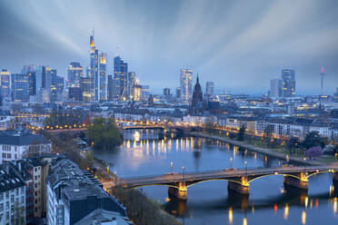 Langzeitbelichtung von Wolken in der Abenddämmerung über der beleuchteten Stadtsilhouette und der Ignatz-Bubis-Brücke, Frankfurt am Main, Hessen, Deutschland Europa - RHPLF22452