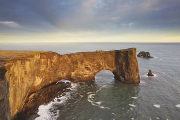 A rock arch on Dyrholaey Island seen in sunset sunlight, near Vik, south coast of Iceland, Polar Regions - RHPLF22457