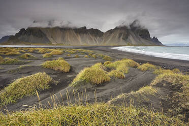 Die schwarzen Sanddünen und Klippen von Vestrahorn von Stokksnes aus gesehen, in der Nähe von Hofn, Südostisland, Polarregionen - RHPLF22466