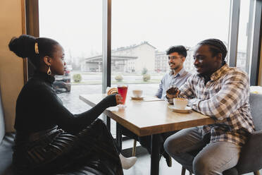 Gemischtrassige Freunde verbringen Zeit miteinander im Cafe - OSF00337