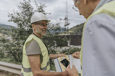 Senior engineer having discussion with colleague on plan - MFF09263