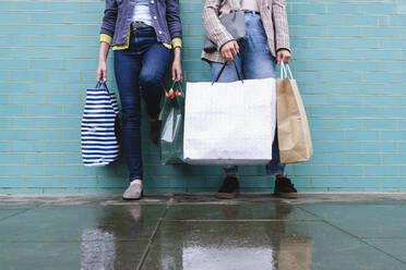Frauen mit Einkaufstaschen auf nassem Gehweg - ASGF02581