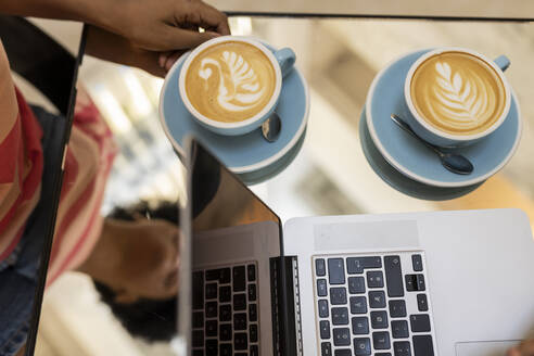 Kellnerin serviert Cappuccino in einem Kaffeehaus - JCCMF06720