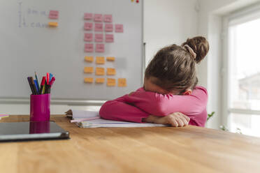 Girl crying over book on table at home - OSF00368