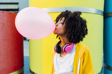 Young woman with eyes closed blowing bubble gum - MEUF06996