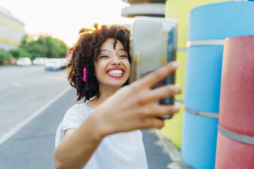 Glückliche junge Frau nimmt Selfie durch Smartphone - MEUF07004