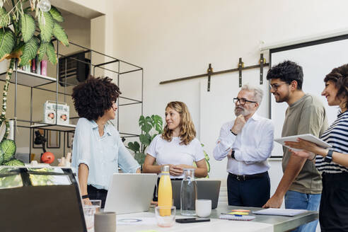 Kollege bespricht sich mit dem Team bei einer Besprechung im Büro - MEUF07036