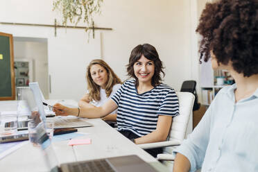 Happy business colleagues planning together at work place - MEUF07072