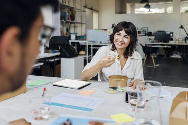 Smiling businesswoman having with colleague in break at office - MEUF07122