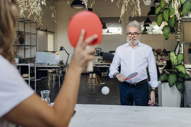 Manager spielt Tischtennis mit einem Kollegen im Büro - MEUF07153