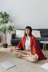 Woman with eyes closed doing yoga at home - MEUF07210