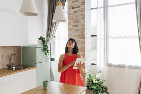 Woman using home automation in kitchen at home - MEUF07250