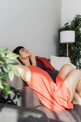 Woman relaxing on sofa at home - MEUF07255