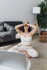 Woman sitting with hands clasped at home - MEUF07274