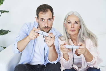 Mother and son playing video game with game controllers at home - VEGF05676