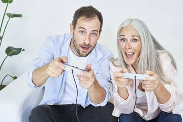 Excited man with mother enjoying playing video game at home - VEGF05678