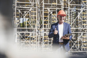 Senior engineer with tablet PC gesturing thumbs up - UUF26837