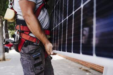 Technician carrying heavy solar panel - EBBF05676