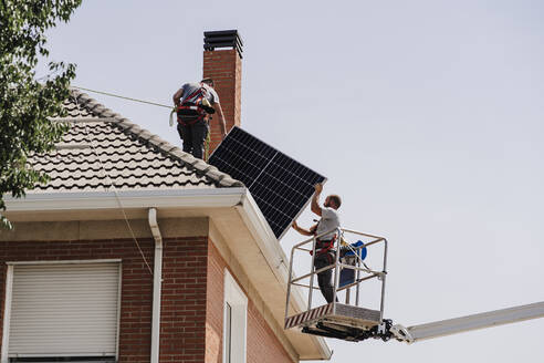 Techniker bei der Installation von Solarzellen auf dem Dach - EBBF05687