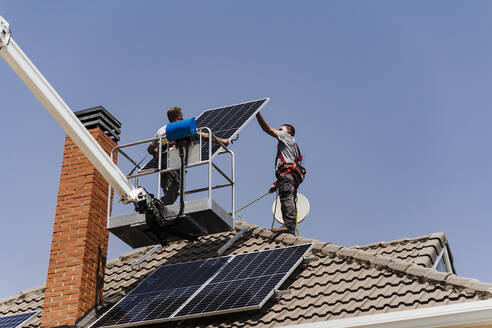 Technicians unloading solar panel from hydraulic platform - EBBF05696