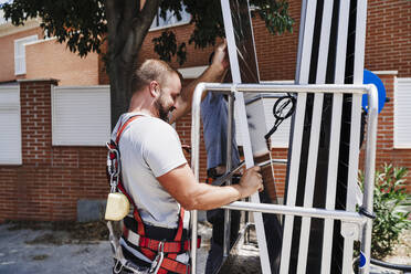 Techniker laden Solarmodule in die Hebebühne - EBBF05702