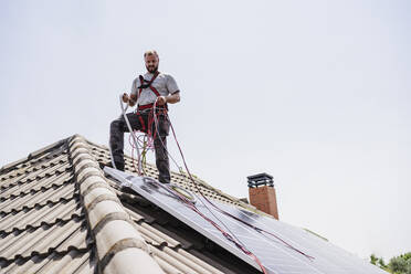 Handwerker bei der Installation von Solarzellen auf dem Dach - EBBF05710