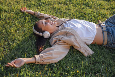 Frau im Gras liegend im Park - VPIF06760