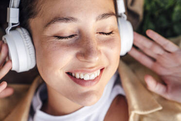 Smiling woman with headphones listening music - VPIF06772