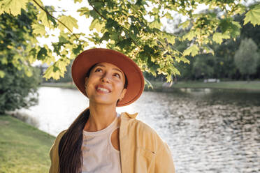 Kontemplative Frau am See im Park - VPIF06775