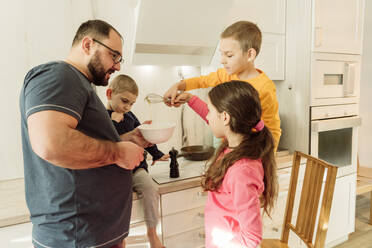 Vater mit Kindern macht Omelett in der Küche - OSF00397