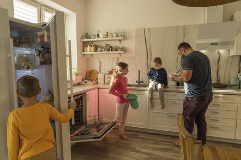 Mädchen und Jungen mit Vater in der Küche zu Hause - OSF00404