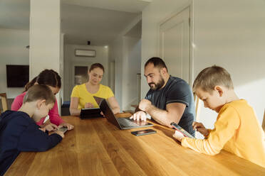 Familie nutzt drahtlose Technologien auf dem Tisch zu Hause - OSF00418