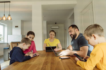 Eltern mit Kindern, die zu Hause drahtlose Technologien nutzen - OSF00419