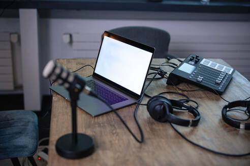 Laptop neben dem Headset auf dem Schreibtisch in der Radiostation - JOSEF11140